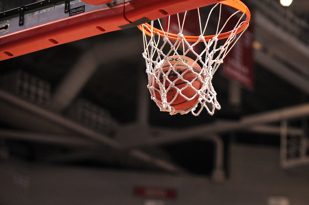 basketball going through hoop in an indoor court